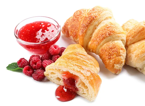 Beyaz arka planda ahududu reçelli lezzetli kruvasanlar.