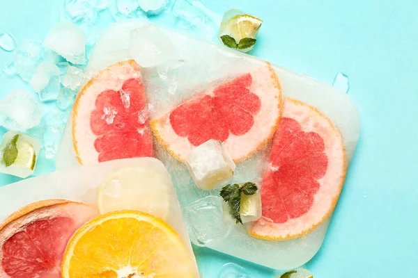 Frische Scheiben Zitrusfrüchte Eingefroren Eis Auf Türkisfarbenem Hintergrund — Stockfoto
