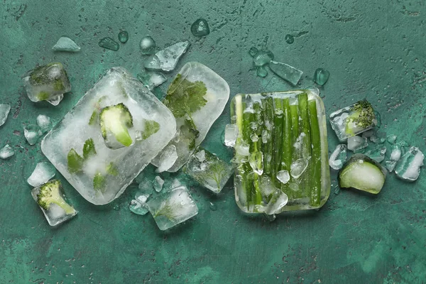 緑の背景に氷の中で冷凍新鮮な野菜 — ストック写真