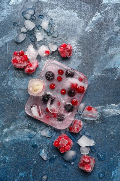 青い背景に氷の中で凍結した新鮮な果実 — ストック写真