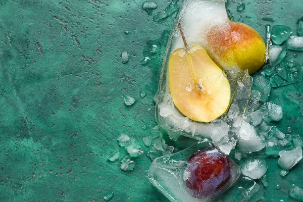 緑の背景に氷の中で凍結した新鮮な果物 — ストック写真