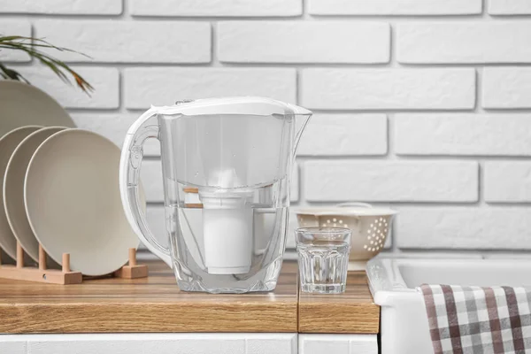 Filter jug and glass of water on counter in kitchen