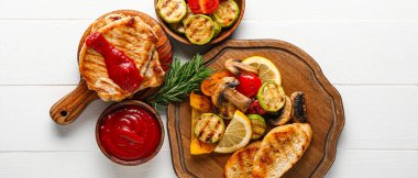 Lezzetli ızgara sebzeli kompozisyon ve beyaz ahşap arka planda tavuk.