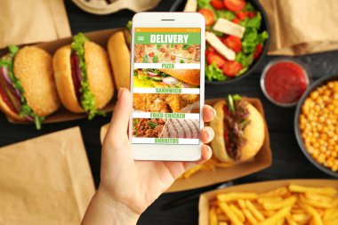 Cep telefonlu bir kadın internetten fast food sipariş ediyor.