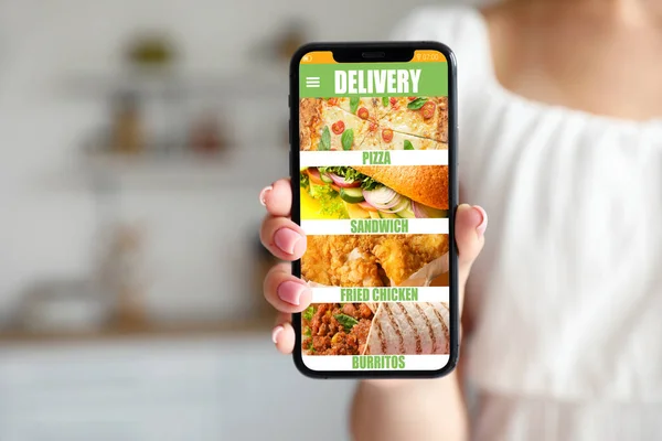 Young woman with smartphone ordering food online, closeup