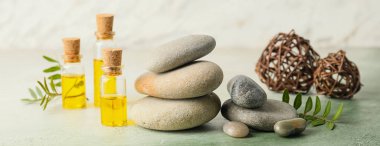 Masaj taşlarıyla güzel bir spa kompozisyonu ve hafif arka planda gerekli yağ.