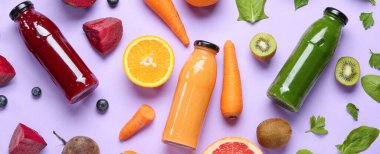 Şişeler dolusu sağlıklı meyve püresi ve eflatun arka planda malzemeler.