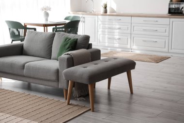 Modern odada kanepenin yanında yumuşak bir bank.