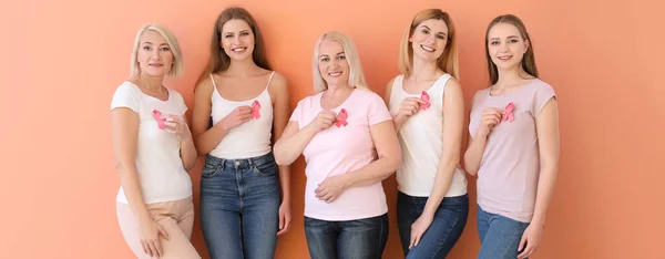 Schöne Frauen Unterschiedlichen Alters Mit Rosa Schleifen Auf Farbigem Hintergrund — Stockfoto