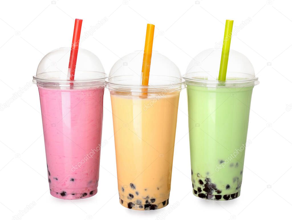 Plastic cups of different tasty bubble tea on white background