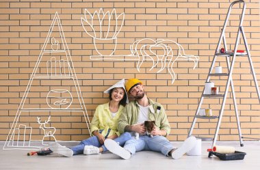 Şirin köpekleri ve resim aletleri olan genç çift oturma odasının yeni tasarımını hayal ediyor.