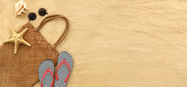 Plaj çantası ve aksesuarları kumda metin ve üst görünüm için yer var.