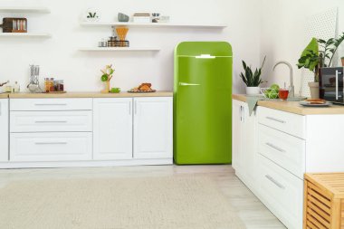 Yeşil buzdolabı olan hafif mutfağın içi. 