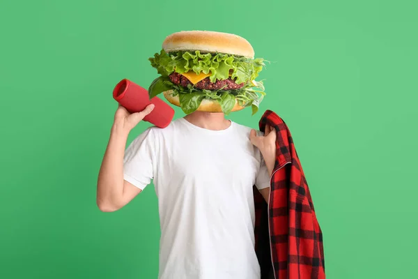 Человек Вкусным Бургером Вместо Головы Зеленом Фоне — стоковое фото