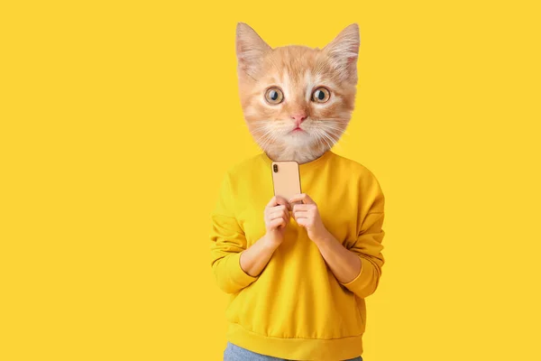 Милая Кошка Человеческим Телом Держит Смартфон Желтом Фоне — стоковое фото