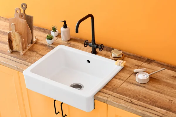 Wooden Counter Ceramic Sink Cleaning Supplies Orange Wall Kitchen — Stock Photo, Image