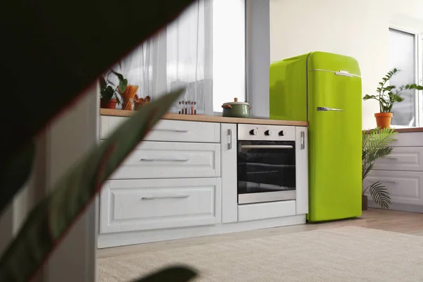 Interior of light modern kitchen with green vintage fridge