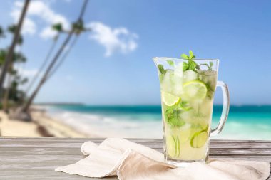 Tropikal tatil yerindeki masada bir sürahi taze mojito.