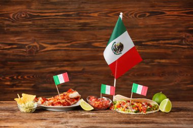 Geleneksel Meksika yemekleri ve tahta arka planda bayrakları olan kompozisyon