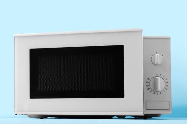 Mavi zemin üzerinde yeni modern mikrodalga fırın