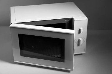 Işık arka planında yeni modern mikrodalga fırın