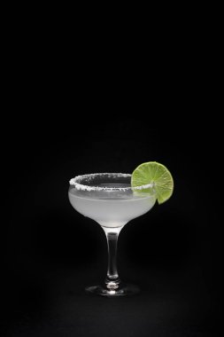 Koyu arkaplanda bir bardak margarita kokteyli.
