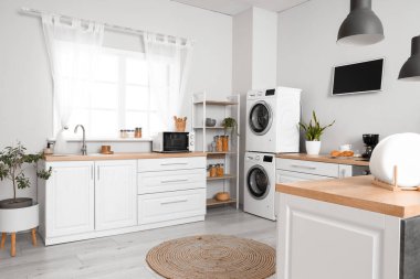 Modern çamaşır makineleriyle mutfağın iç dekorasyonu.