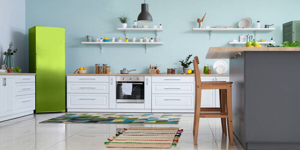 Interior of modern comfortable kitchen with green fridge