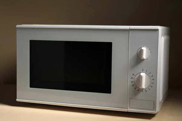 New modern microwave oven on color background