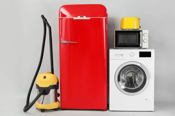 Modern household appliances on light background