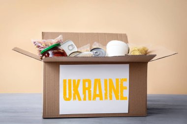 Renkli arka planda masada yiyecek olan bir kutu. Ukrayna için insani yardım