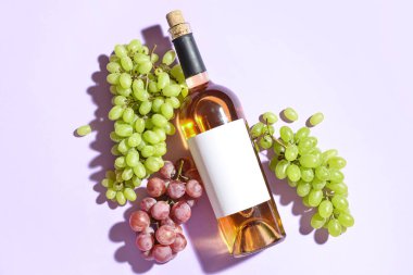 Taze üzüm ve arka planda bir şişe şarap.