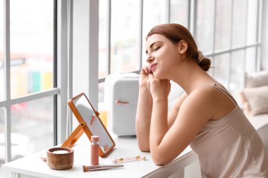 Kozmetik ürünleri için küçük buzdolabı olan güzel bir kadın.