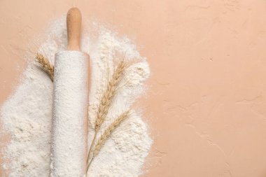 Renkli arka planda yuvarlanan iğne ve buğday unu