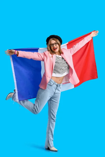 青い背景にフランスの旗を持つ美しい幸せな若い女性 — ストック写真