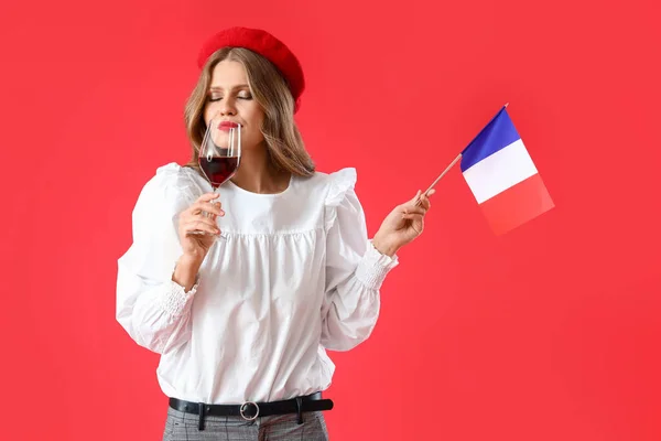赤の背景にフランスとワインの旗を持つ美しい若い女性 — ストック写真
