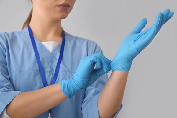 Female Nurse Putting Rubber Gloves Grey Background — Stock Photo, Image