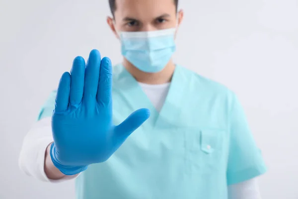 Manlig Sjuksköterska Medicinsk Mask Visar Stop Gest Ljus Bakgrund — Stockfoto