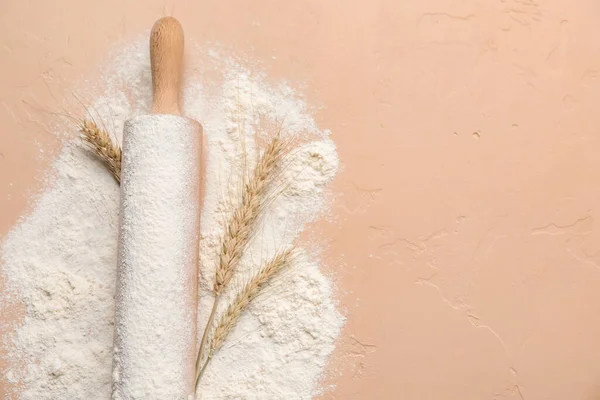 Renkli arka planda yuvarlanan iğne ve buğday unu