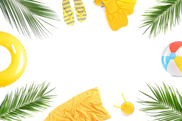 Beyaz arka planda plaj aksesuarları ve tropikal yapraklardan yapılmış çerçeve