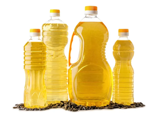 Beyaz zemin üzerinde yağ ve ayçiçeği tohumları olan farklı şişeler.