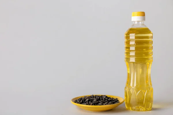 Бутылка Масла Пластины Семенами Подсолнечника Сером Фоне — стоковое фото