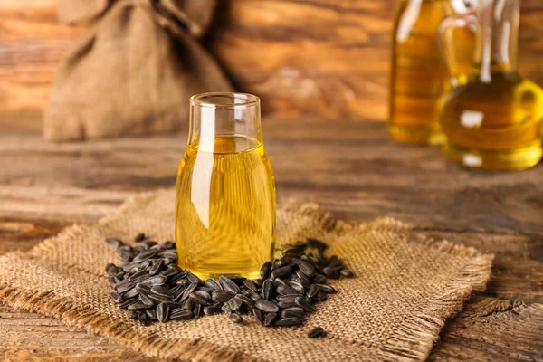 Ahşap zemin üzerinde cam yağ şişesi ve ayçekirdeği.