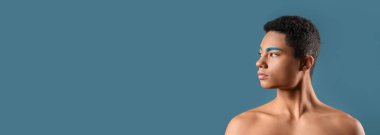 Mavi arka planda alışılmadık kaşları olan ve mesaj atmak için yeri olan şık bir genç.