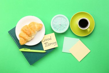 Lezzetli kahvaltılı kompozisyon, yeşil arka planda çalar saat ve kırtasiye malzemesi