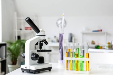 Modern mikroskop ve test tüpleri tıbbi laboratuardaki masada.