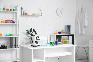 Tıp laboratuarında mikroskop ve kimyasal cam ile modern işyeri