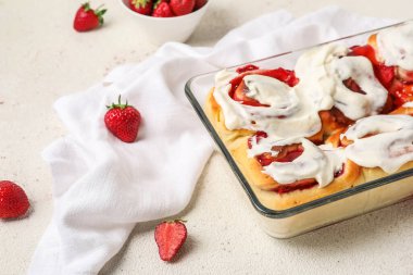 Beyaz arka planda çilekli tarçınlı yemek ve krema.