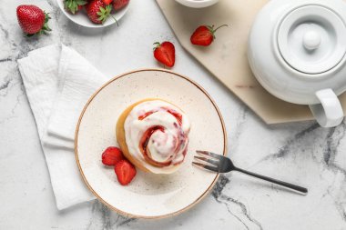 Çilekli tarçınlı tabak ve grunge arkaplanda çaydanlık.