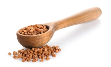 Beyaz zemin üzerinde karabuğday olan tahta kaşık.